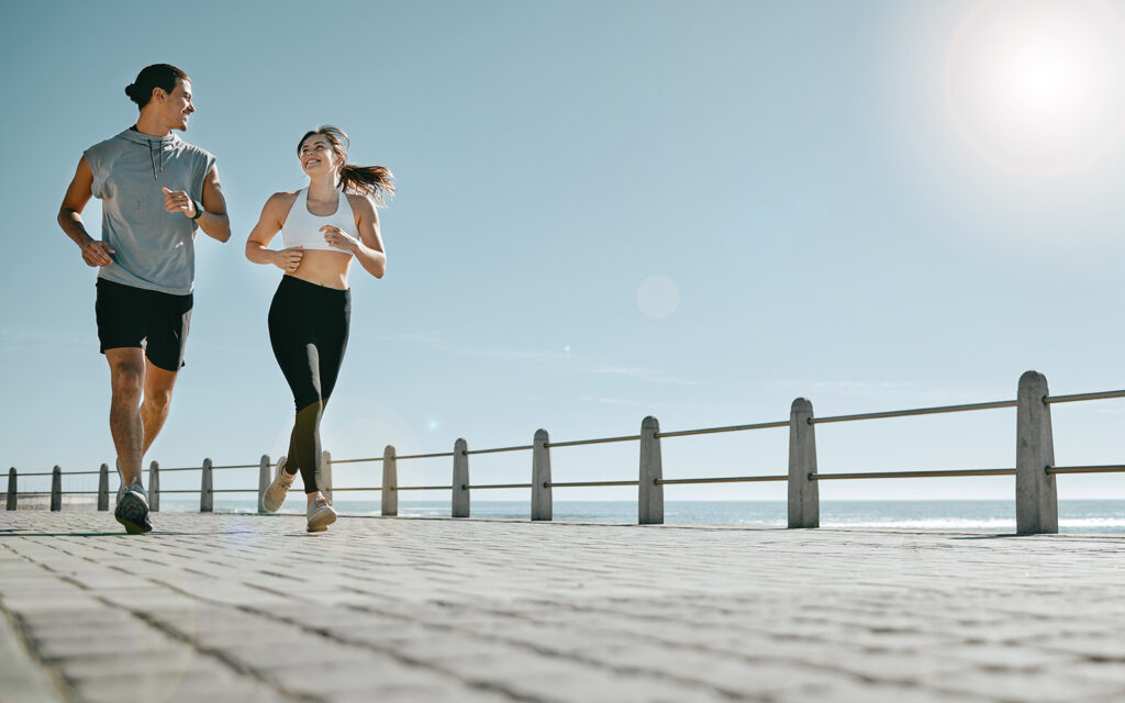 Couple running on pier with sunny weather